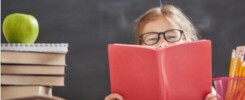 A kid holding and reading a book