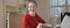 An office woman smiling and happily working at her desk